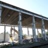 Bagr se zakusuje do přestavby objektu "skladu řeziva" / Foto: ČD